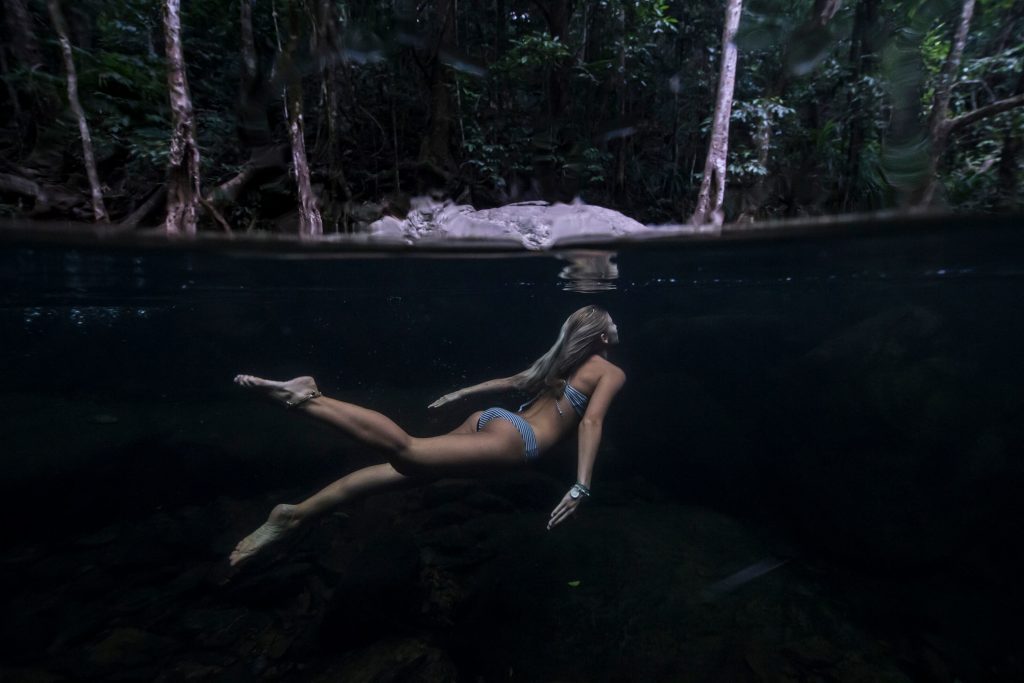 girl swimming underwater in freshwater creek